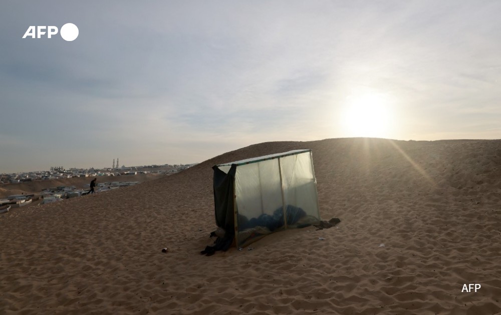 AFP picture - A displaced Palestinian sleeps in a makeshift tent at a camp in Rafah, Gaza Strip