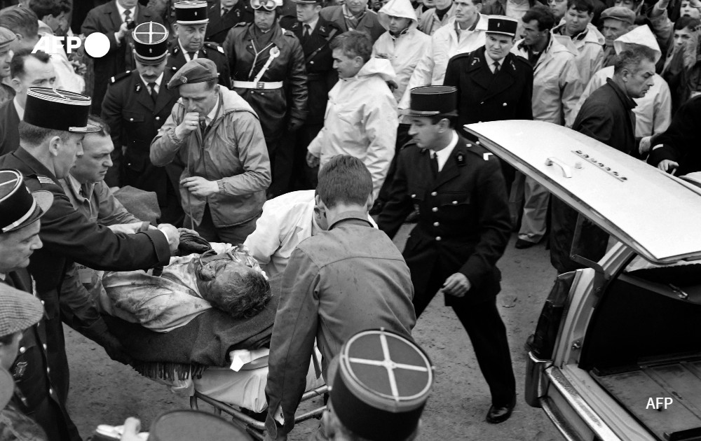 Rescuers carry away American race car driver Walter Hansgen, 1966