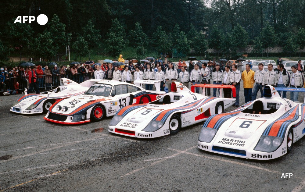 Martini Racing Porsche System team race drivers pose near the Porsche 936 cars, 1978