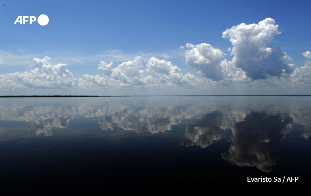 Clouds reflect on the Black River waters near the village of Tumbira, in the Amazon, northern Brazil