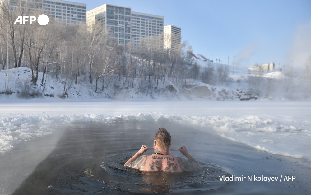 A man swims in an ice hole 