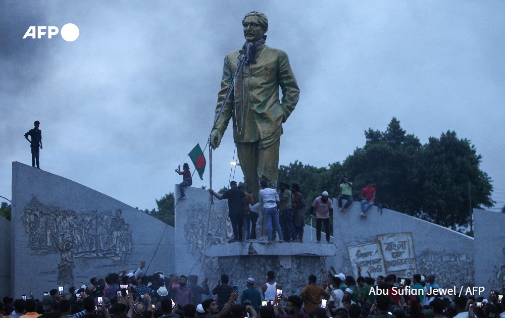 Protestors attempt to vandalise a statue of Sheikh Mujibur Rahman