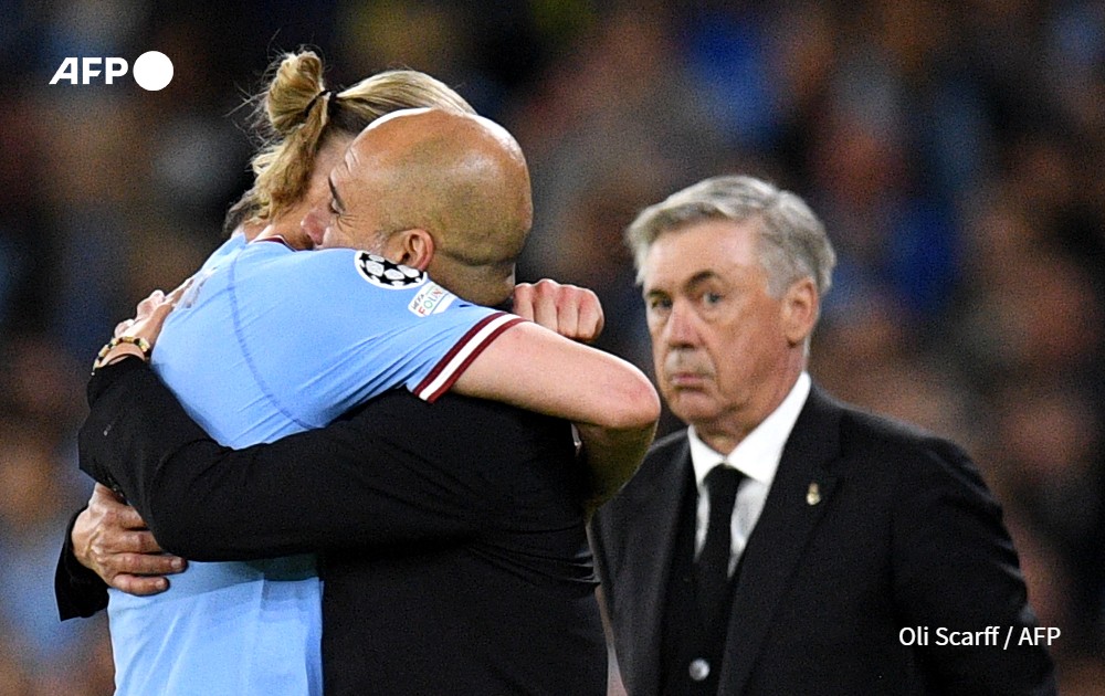 Pep Guardiola embraces Manchester City's Norwegian striker Erling Haaland during the UEFA Champions League