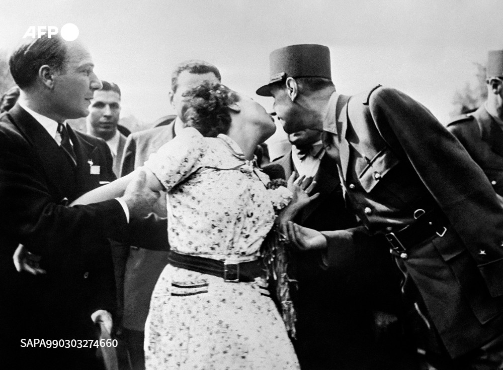 Une Parisienne, l'épouse du caméraman Gaston Madru, manifeste sa joie en embrassant le général de Gaulle lors du défilé du 26 août 1944 sur les Champs-Élysées. © AFP