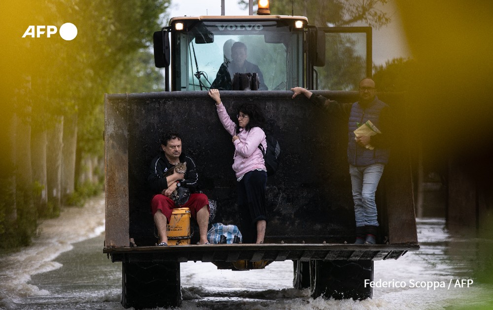 Residents are rescued on a digger after heavy rains have caused major floodings in central Italy.