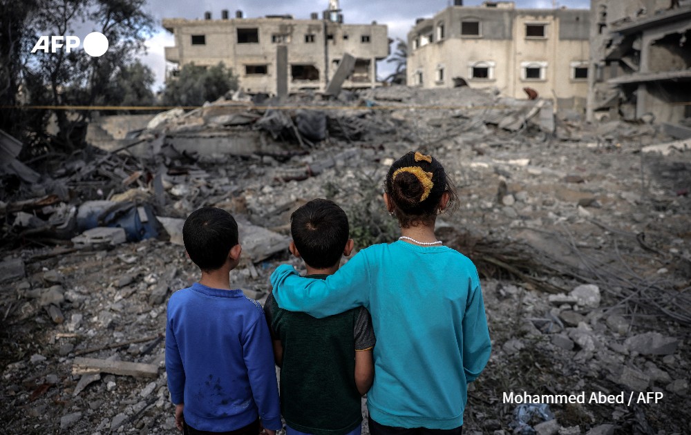 Children stand amidst the rubble of a building hit by an Israeli air strike in the centre of the Gaza Strip.